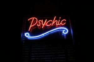 Tarot Reading Reviews red neon sign in window that says psychic with a blue curly line underneath
